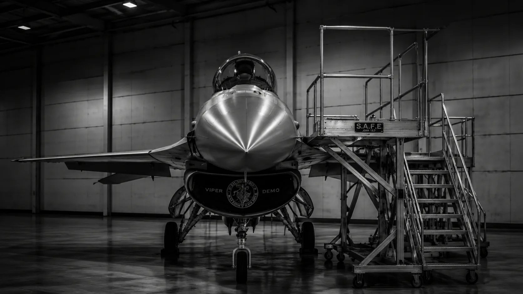 An F-16 in a hangar beside a S.A.F.E. maintenance access platform